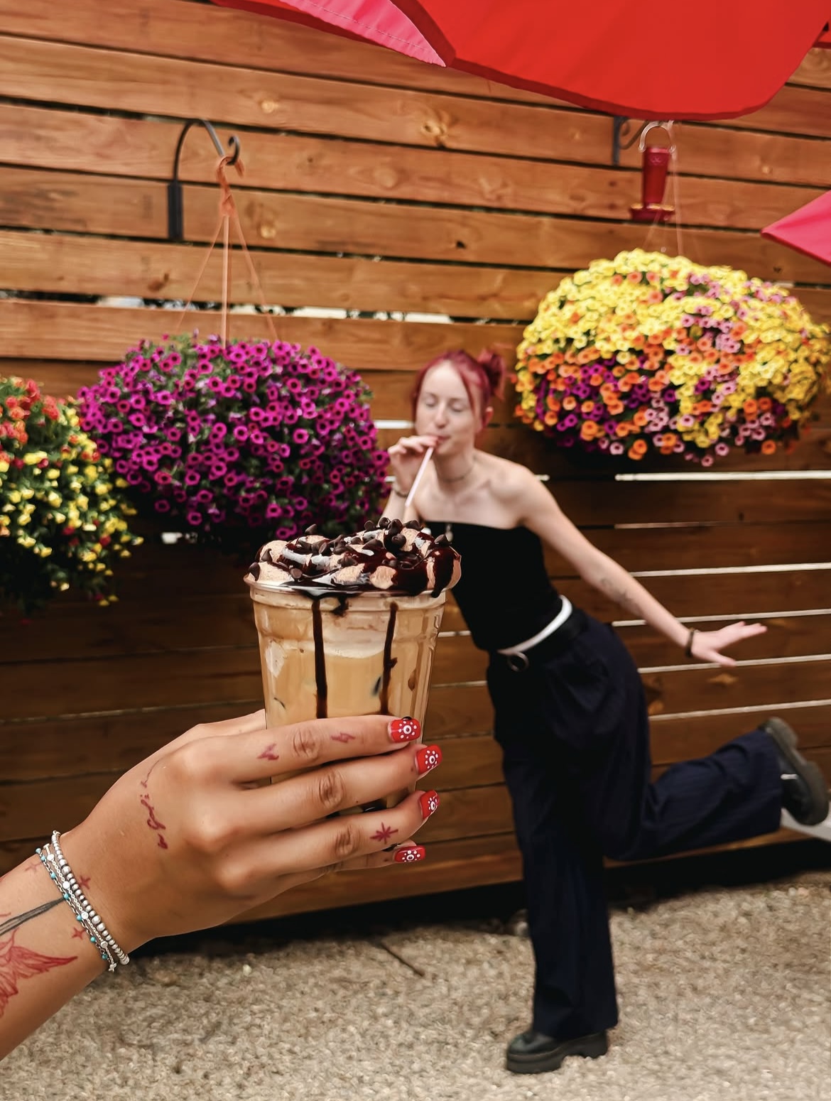A customer mid-leap outside Steam while a friend holds up a chocolate iced drink