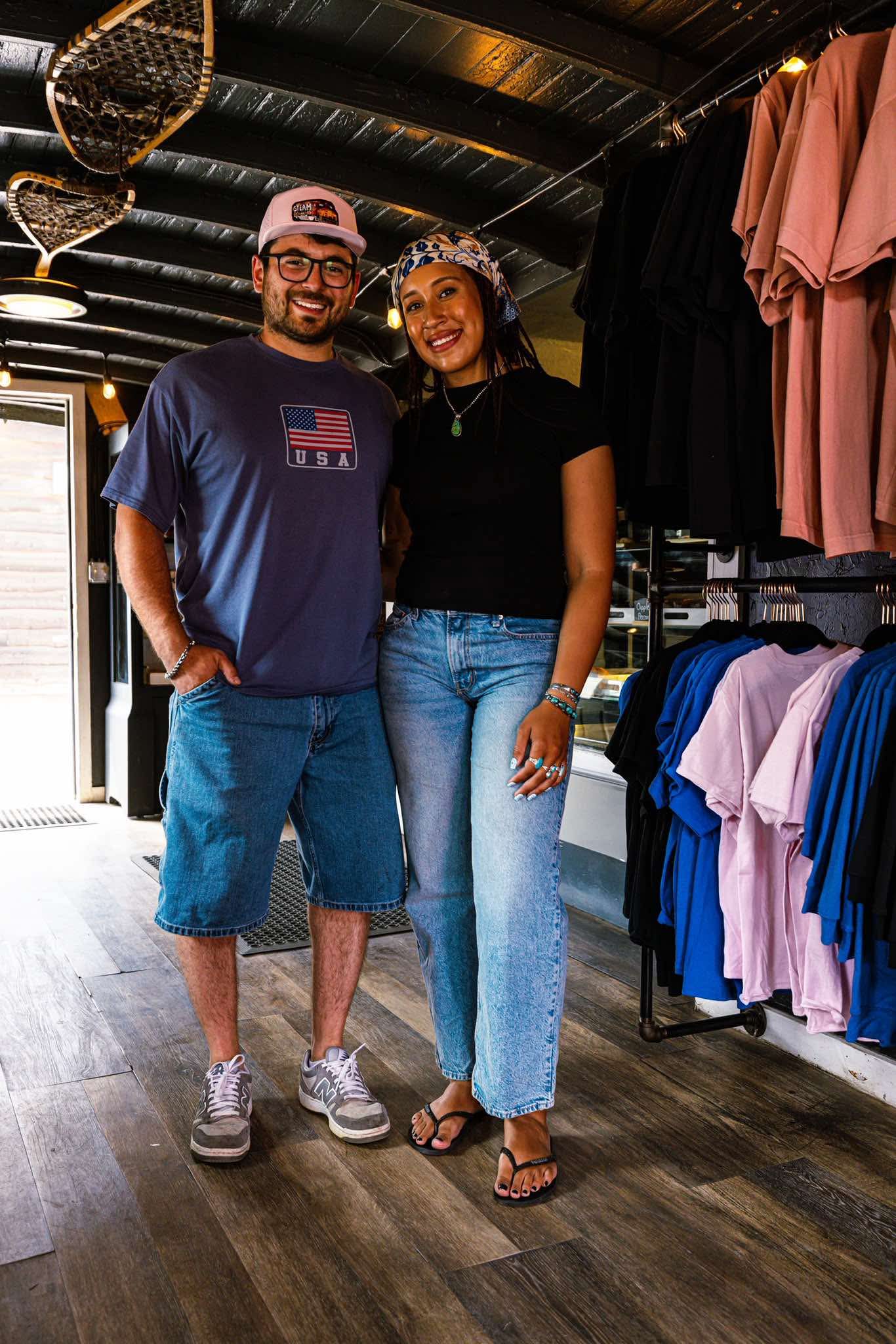 Two customers browsing Steam merchandise inside the shop